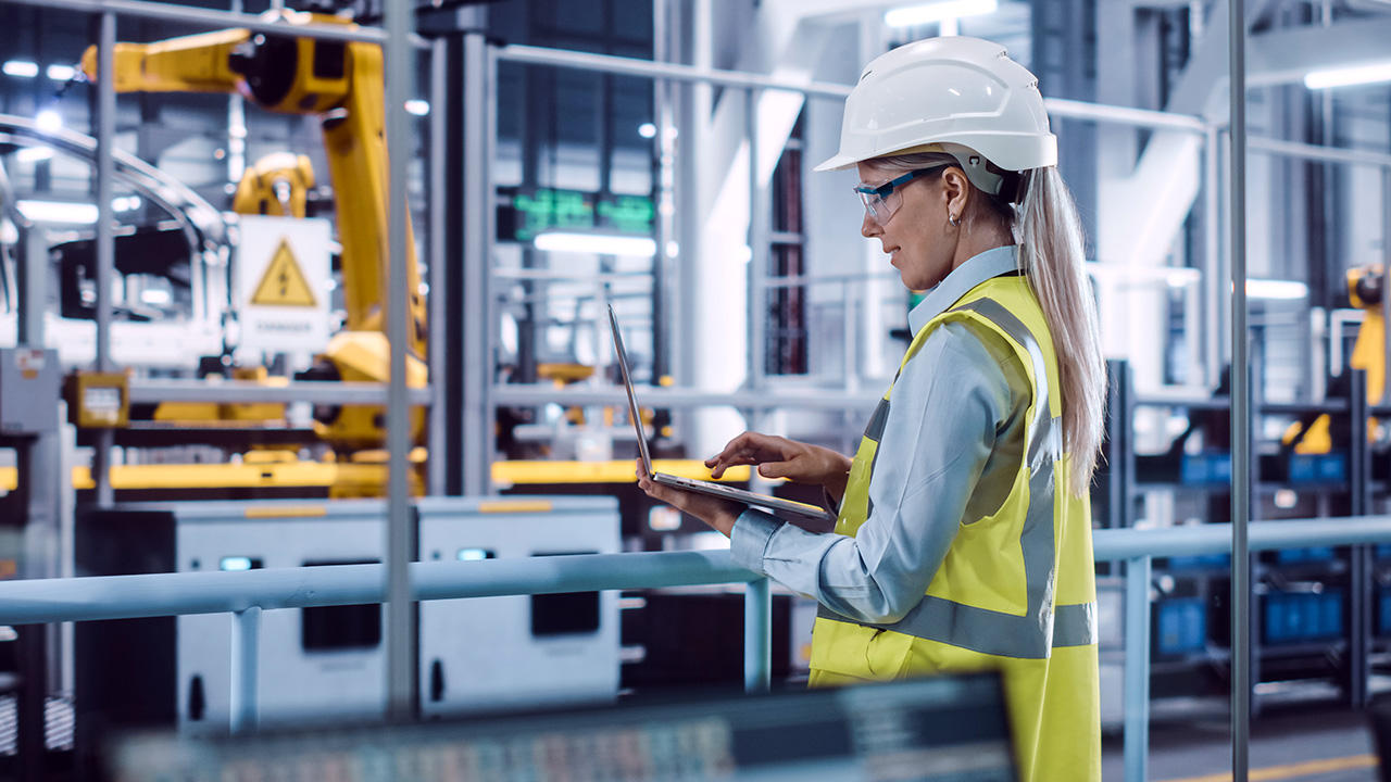 Laptop operator wearing high-viz in a factory